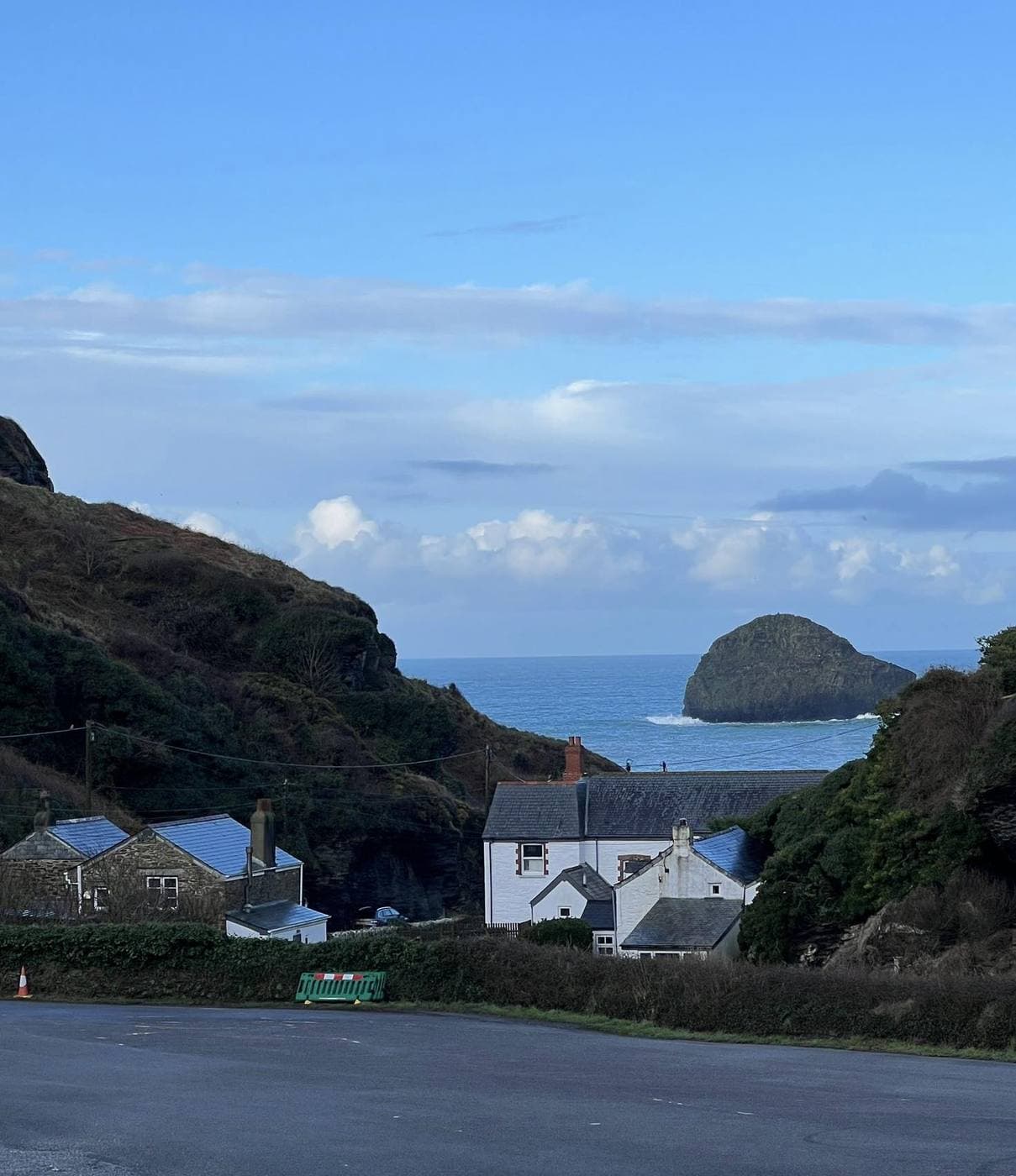 Cornish cottages with the Trebarwith Strand coastline and Gull Rock in the background